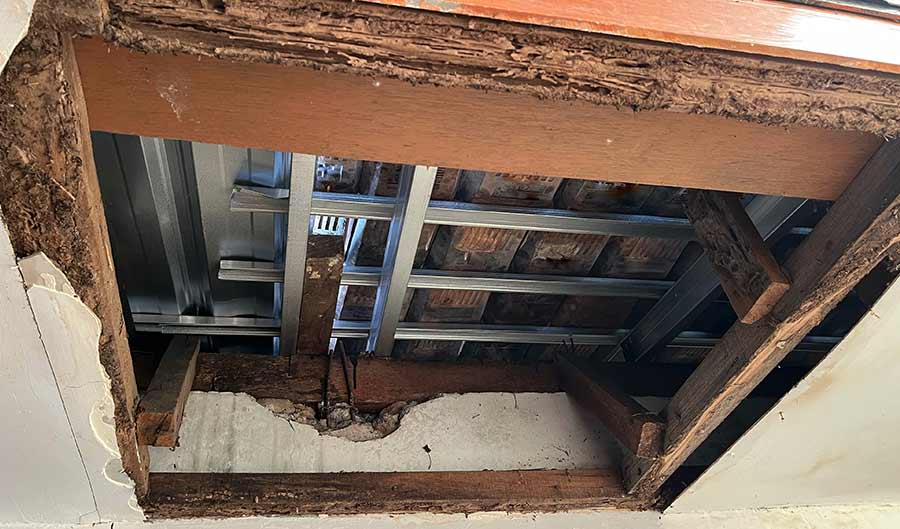 exposed drywall showing termite damage undeneath